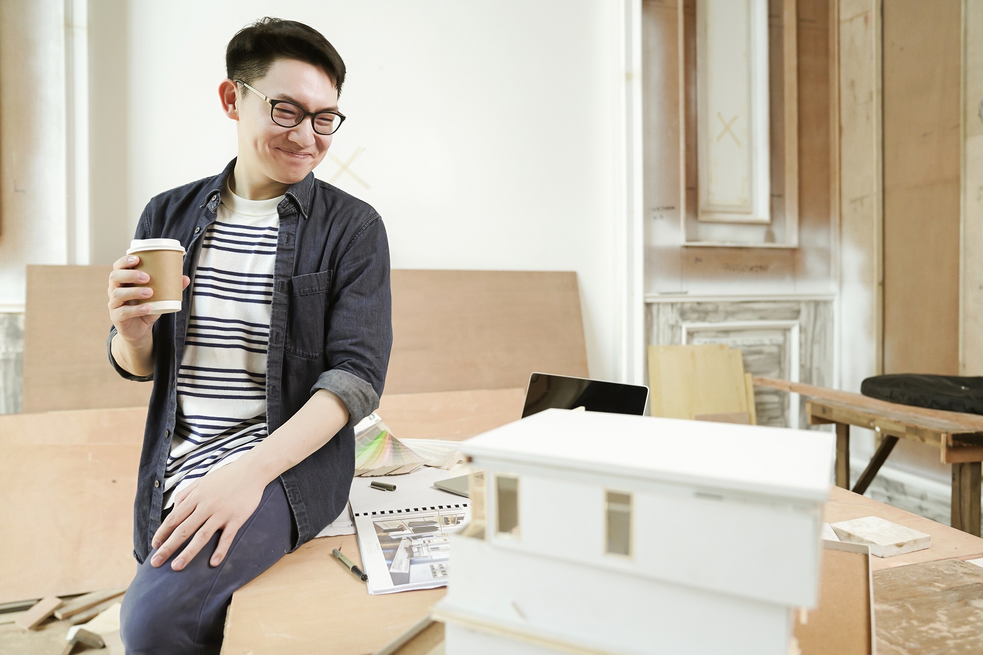 young attractive asian glasses male architect smile confident proud to present new project house model ,happiness asian working with mass model study of house design project