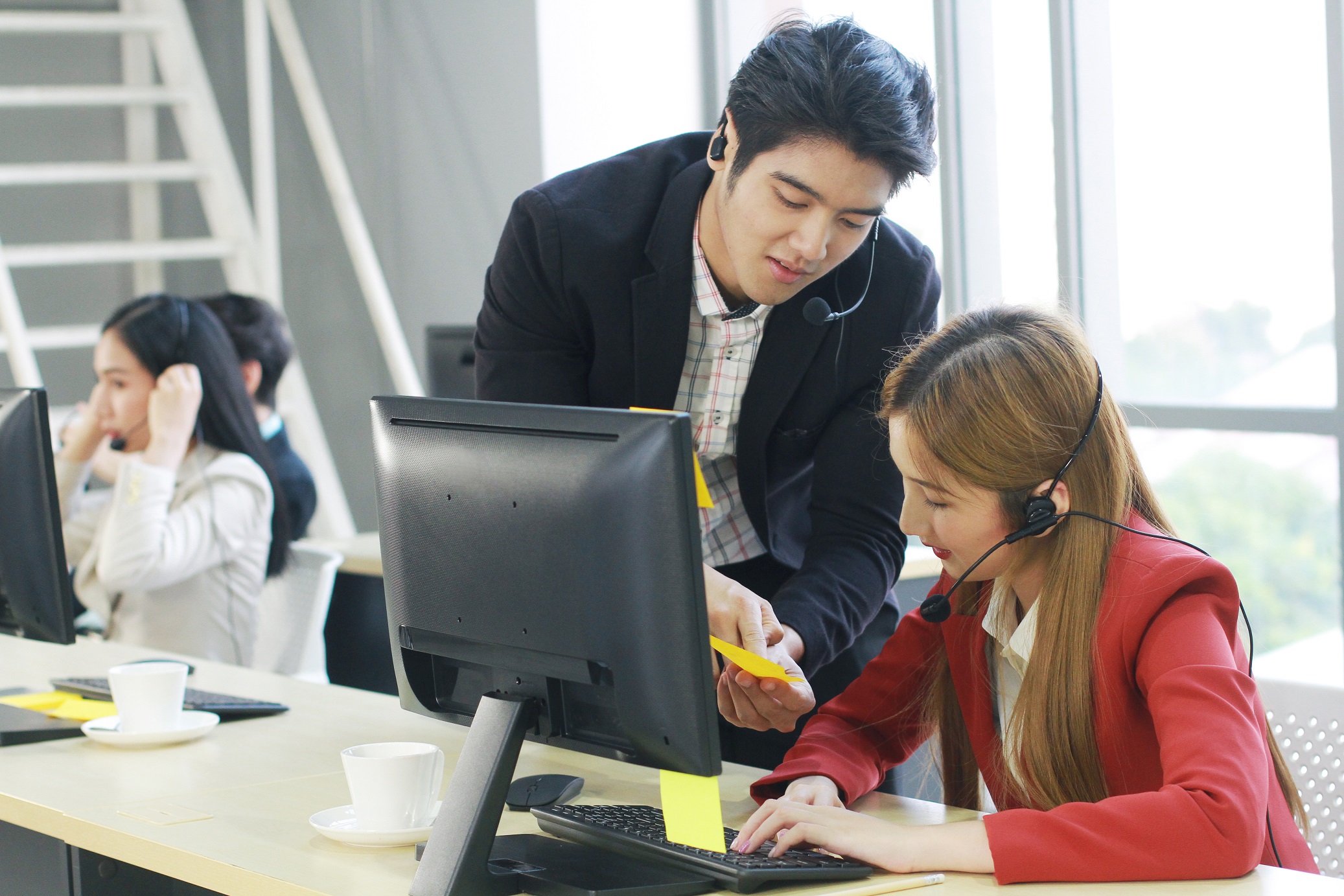 Smiling Business Call Center and technical Support staff or receptionist phone operator Discussing and working for teamwork with computer. Asian customer support team.